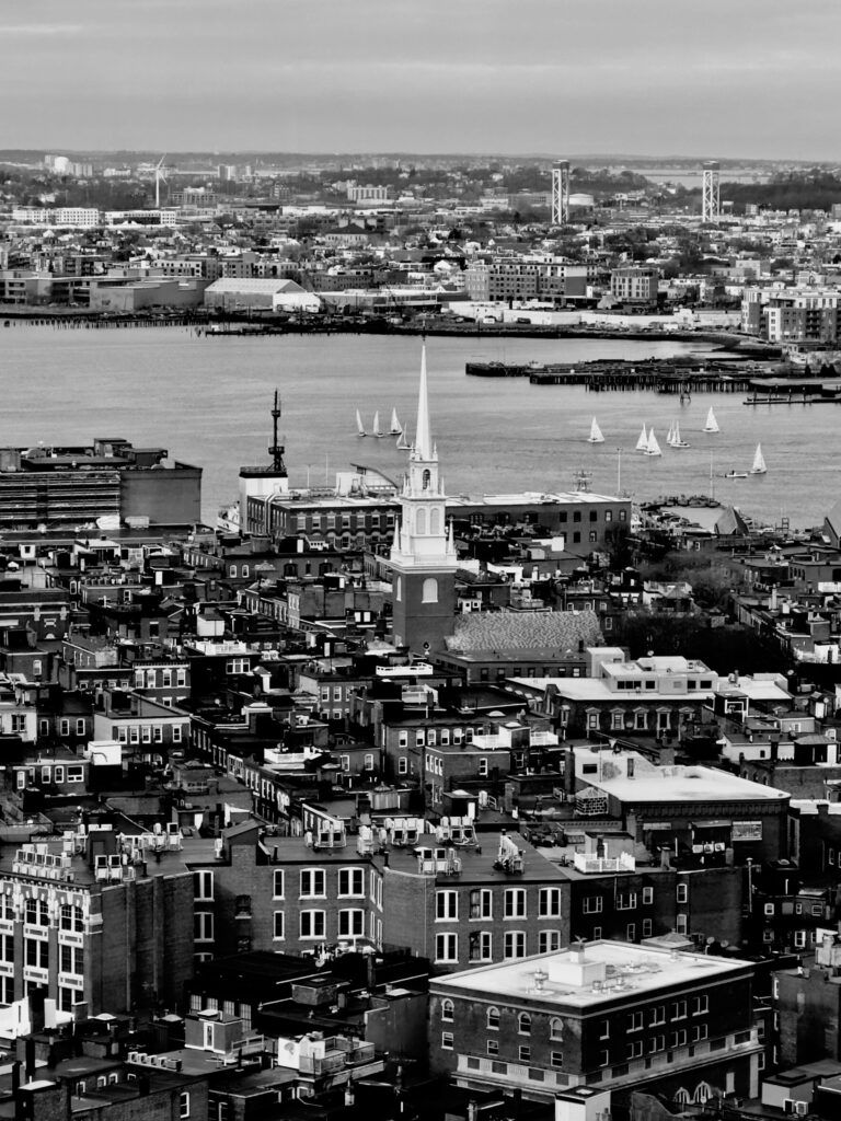 Aerial view of Boston cityscape with prominent church and harbor.